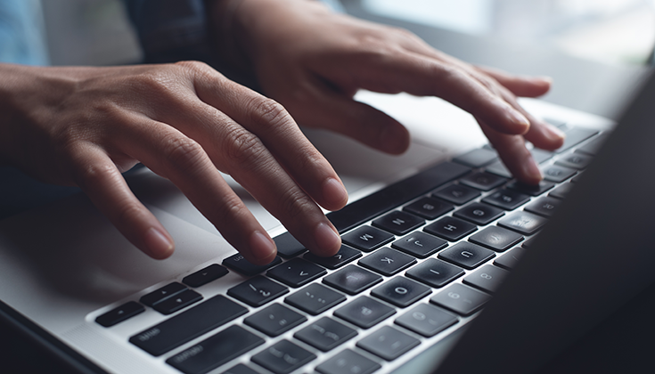 hands typing on computer