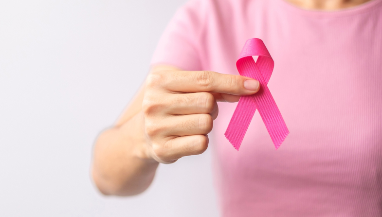woman holding pink breast cancer awareness ribbon