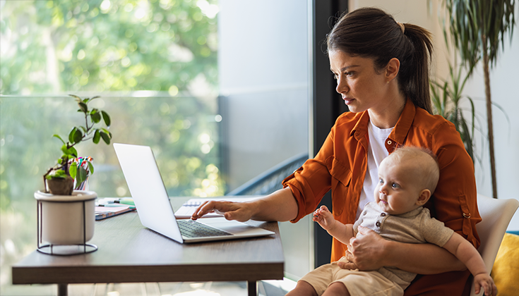 mother and holding toddler on lap while using computer