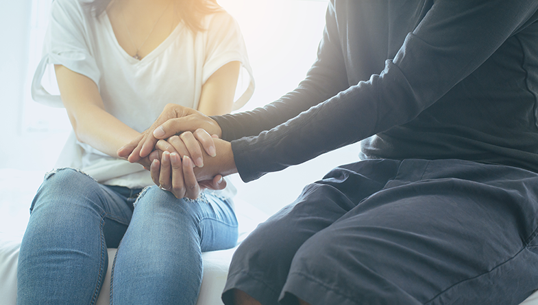 two people holding hands compassionately