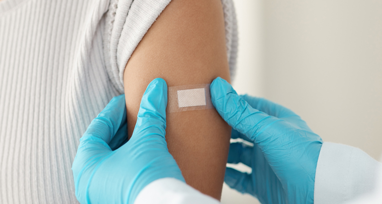bandage being applied after vaccination in arm
