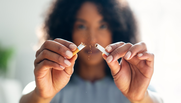 Woman breaking cigarette in half