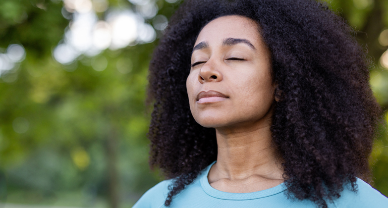 woman with eyes closed enjoying the outdoors