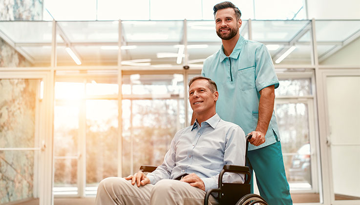 man pushing another man in a wheelchair