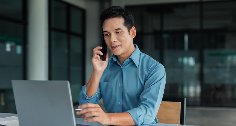 man using computer and using phone