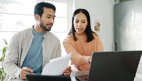 man and woman discussing information on laptop