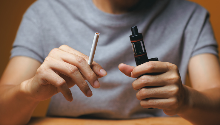 man holding cigarette and vape