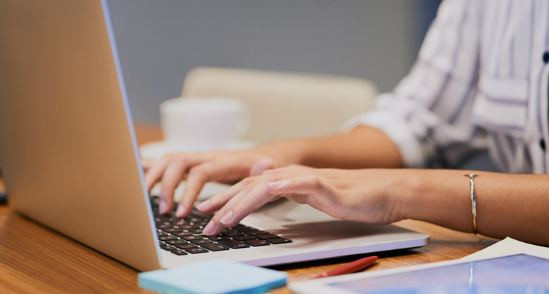 person's hands typing on laptop keyboard