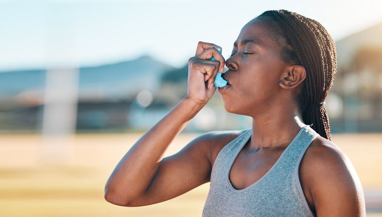 woman using asthma inhaler